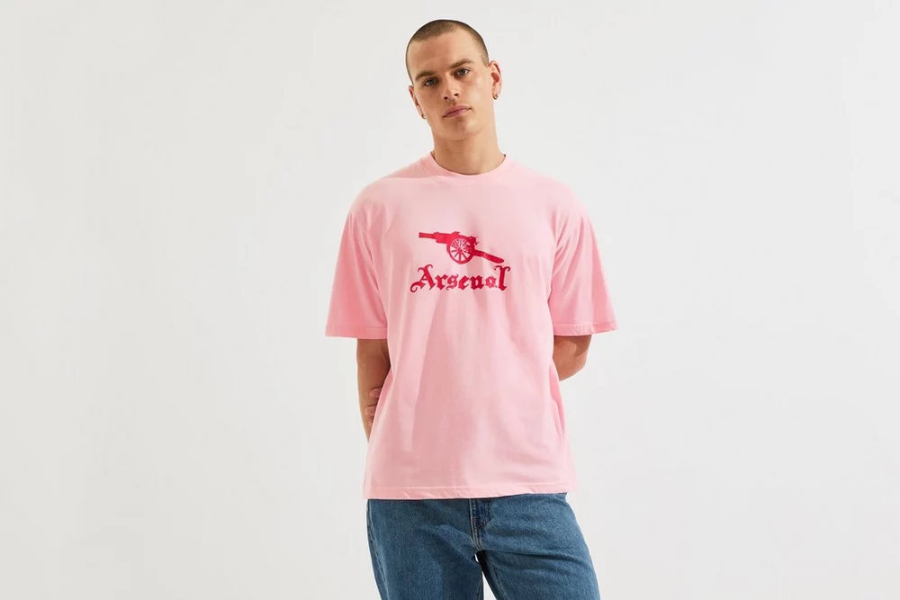 Arsenal Fanshop Store - Arsenal Unisex-T-Shirt mit Briefmarkenprint in Rosa Offizielle Arsenal FC Fußballbekleidung